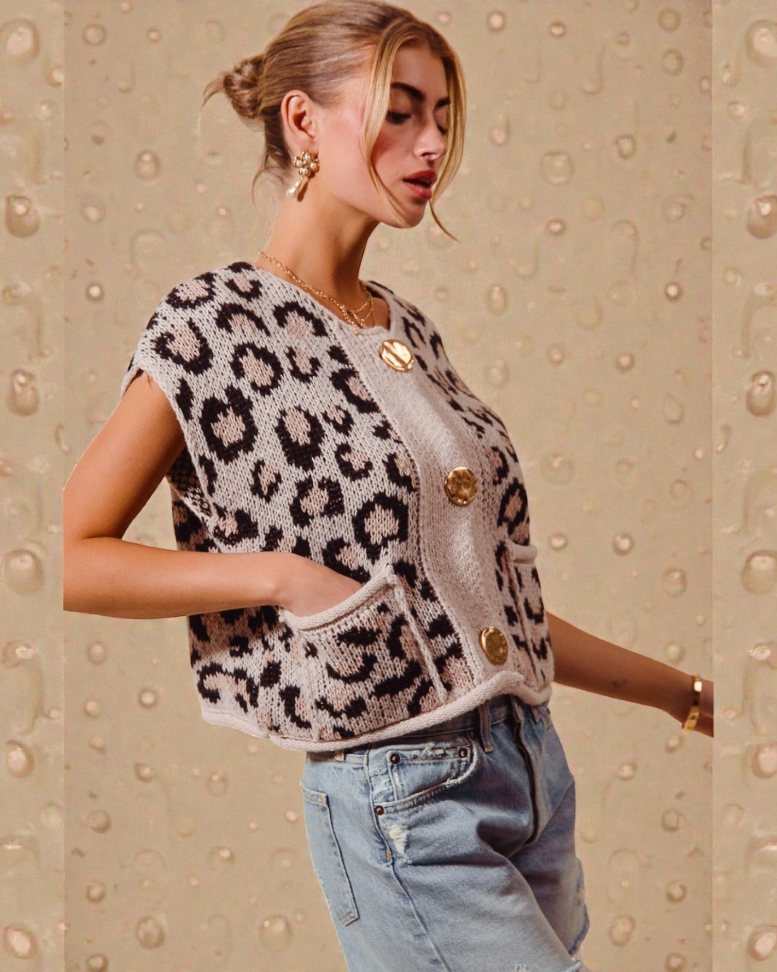 Woman wearing a leopard print vest with gold buttons on a beige background