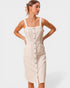 Woman wearing a beige button-up dress against a white background