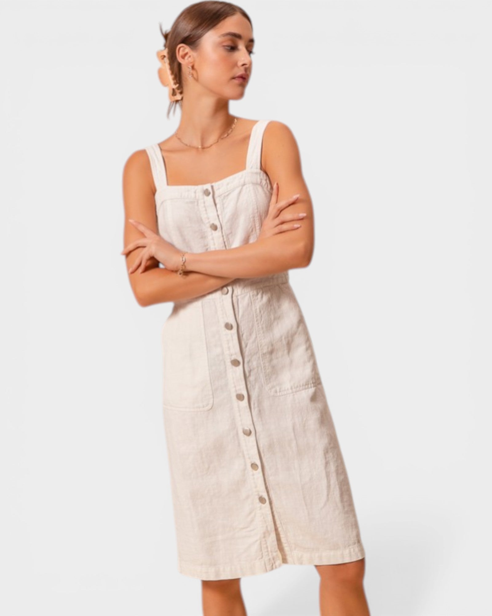 Woman wearing a beige button-up dress against a white background