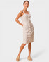 Woman wearing a beige button-up dress on a white background