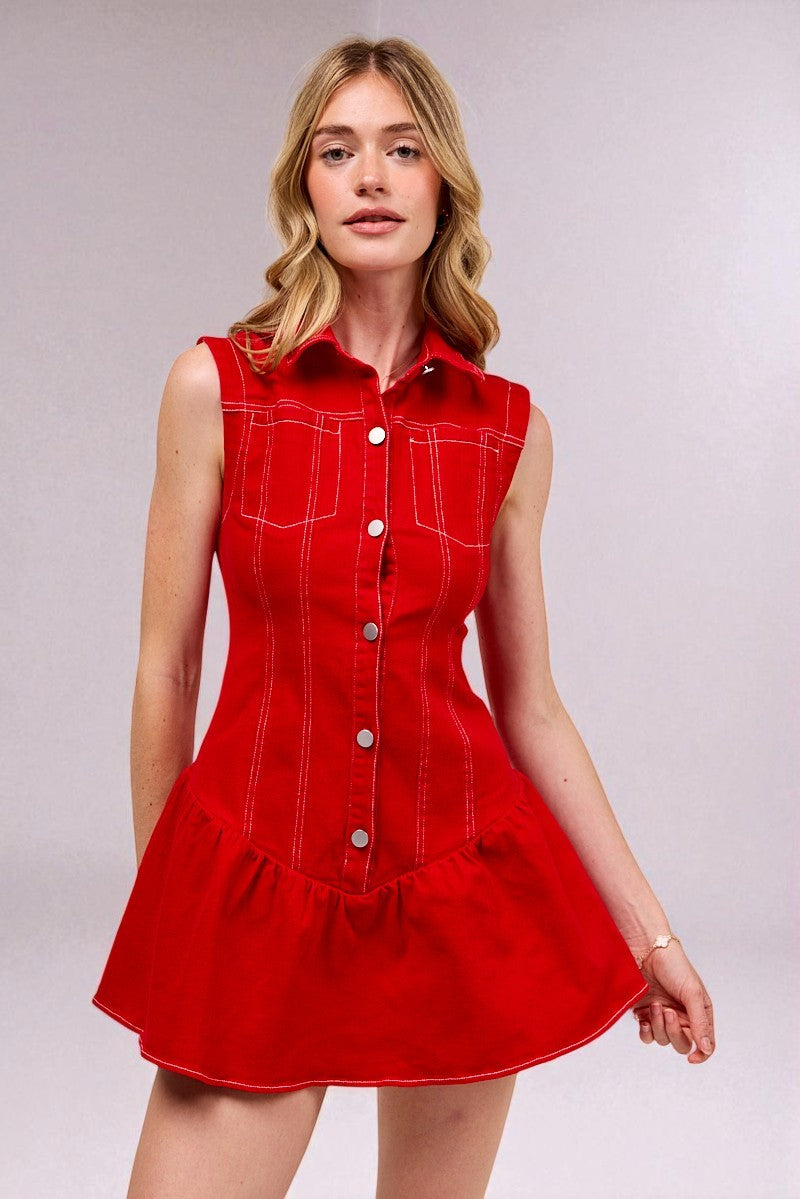 Woman wearing a red dress with white buttons on a plain background