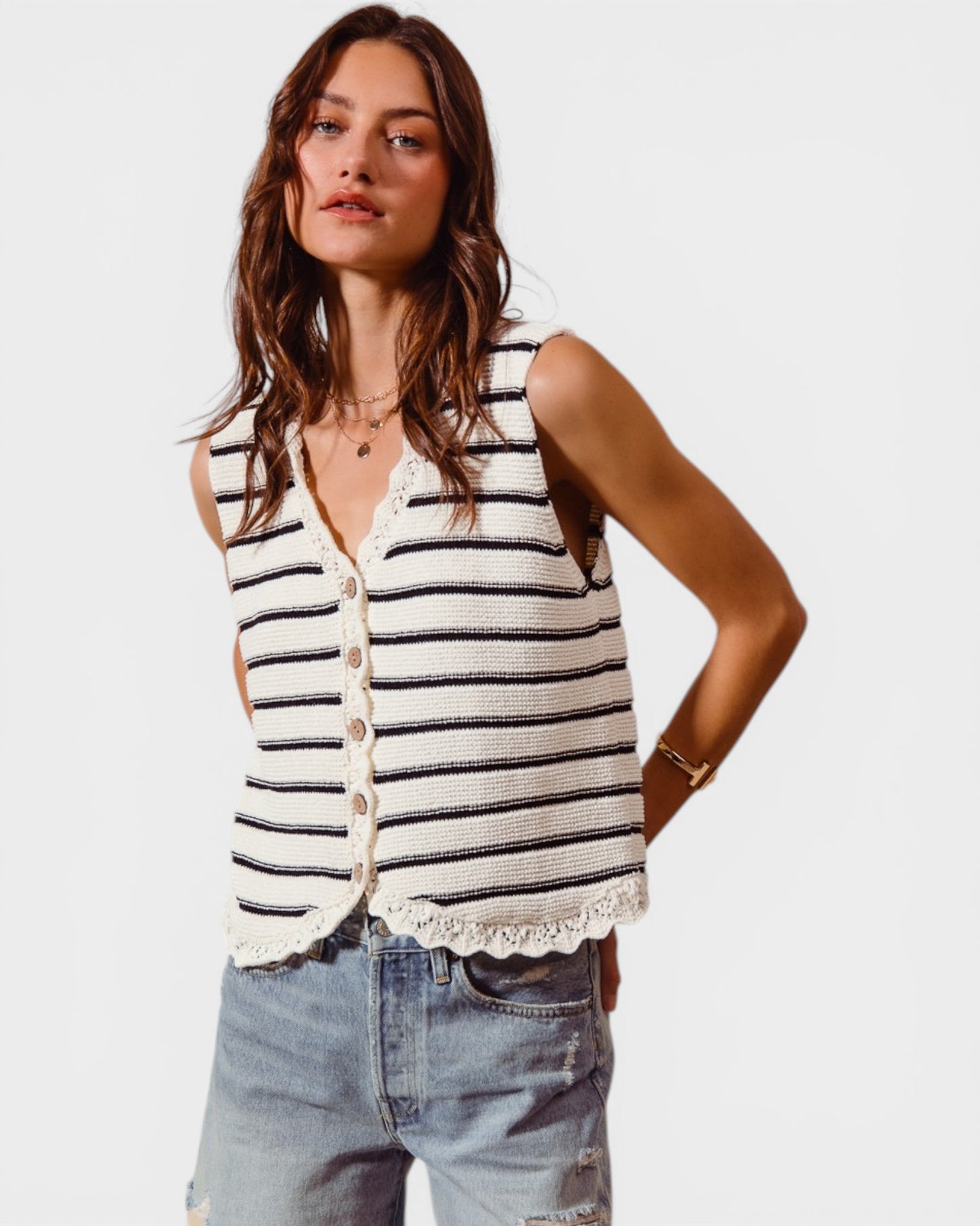Woman wearing a striped sleeveless top and denim shorts on a white background