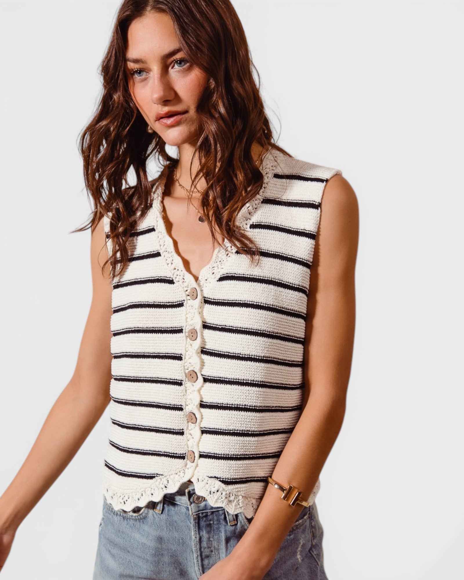 Woman wearing a striped sleeveless top with a plain background
