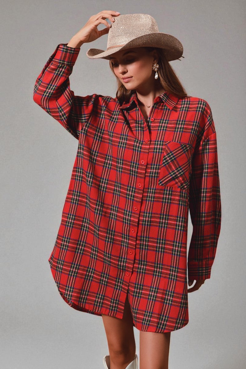 Woman wearing a red plaid shirt dress and cowboy hat against a gray background