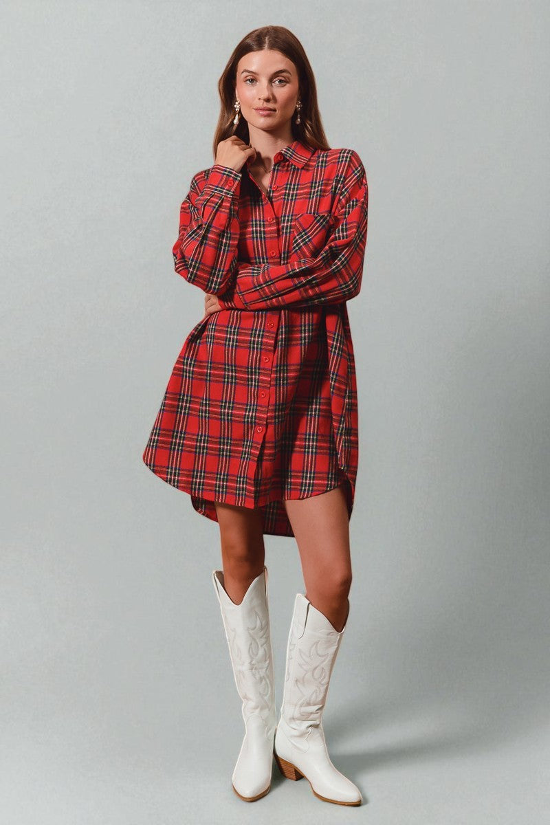 Woman wearing a red plaid dress and white boots on a gray background