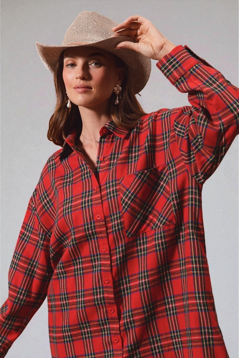 Woman wearing a red plaid shirt and cowboy hat against a gray background