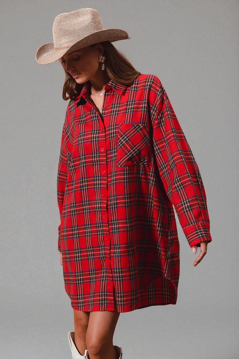 Woman wearing a red plaid dress and beige hat on a gray background