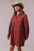 Woman wearing a red plaid dress and cowboy hat against a plain background