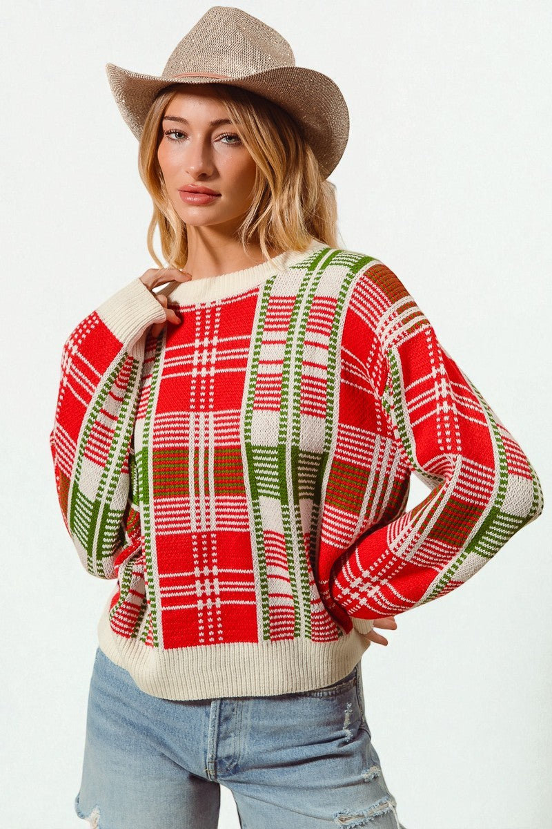 Woman wearing a red plaid sweater with a beige hat on a white background