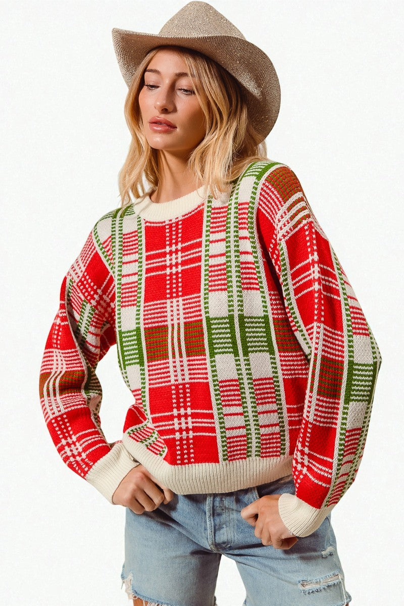 Woman wearing a red and green plaid sweater with a beige hat on a white background