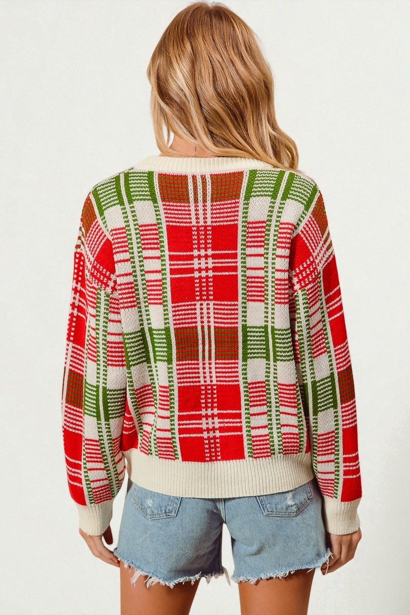 Person wearing a red and green plaid sweater with denim shorts on a white background