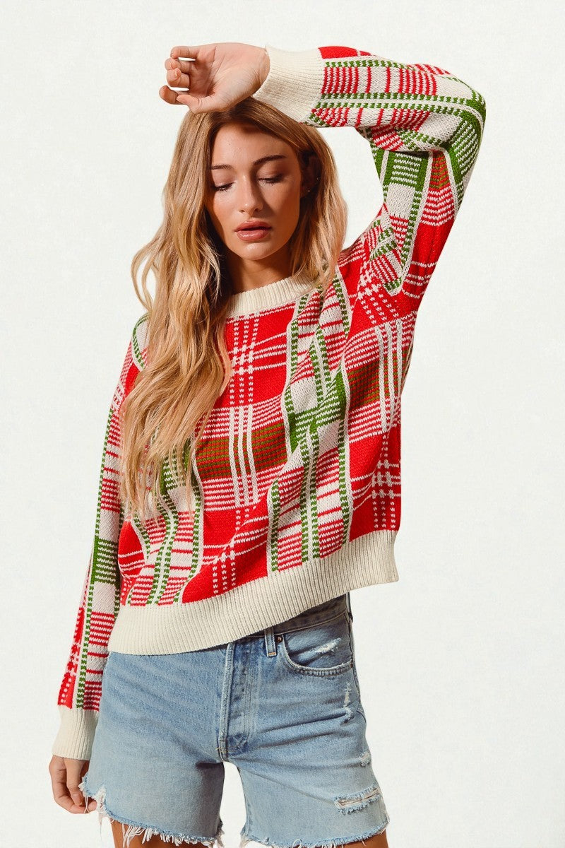 Woman wearing a festive plaid sweater with reindeer design on a white background