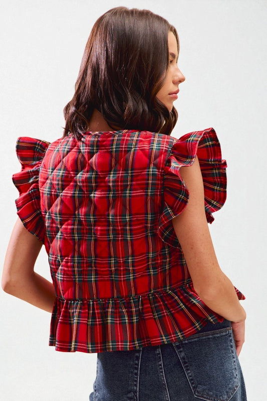 Red plaid blouse with ruffled sleeves worn by a person on a white background