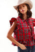 Woman wearing a red plaid top and beige hat on a white background