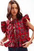 Woman wearing a red plaid blouse with ruffled sleeves on a white background