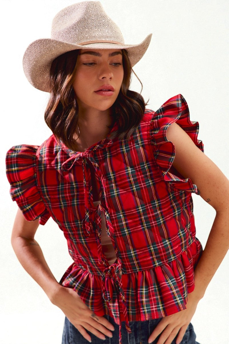 Woman wearing a red plaid top and cowboy hat on a white background