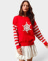Woman wearing a red sweater with a white snowflake design on a plain background
