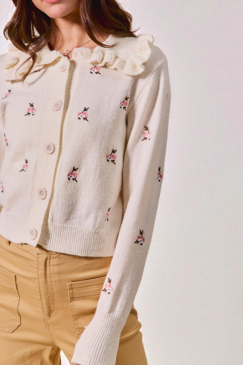 Cream-colored cardigan with floral embroidery on a plain background