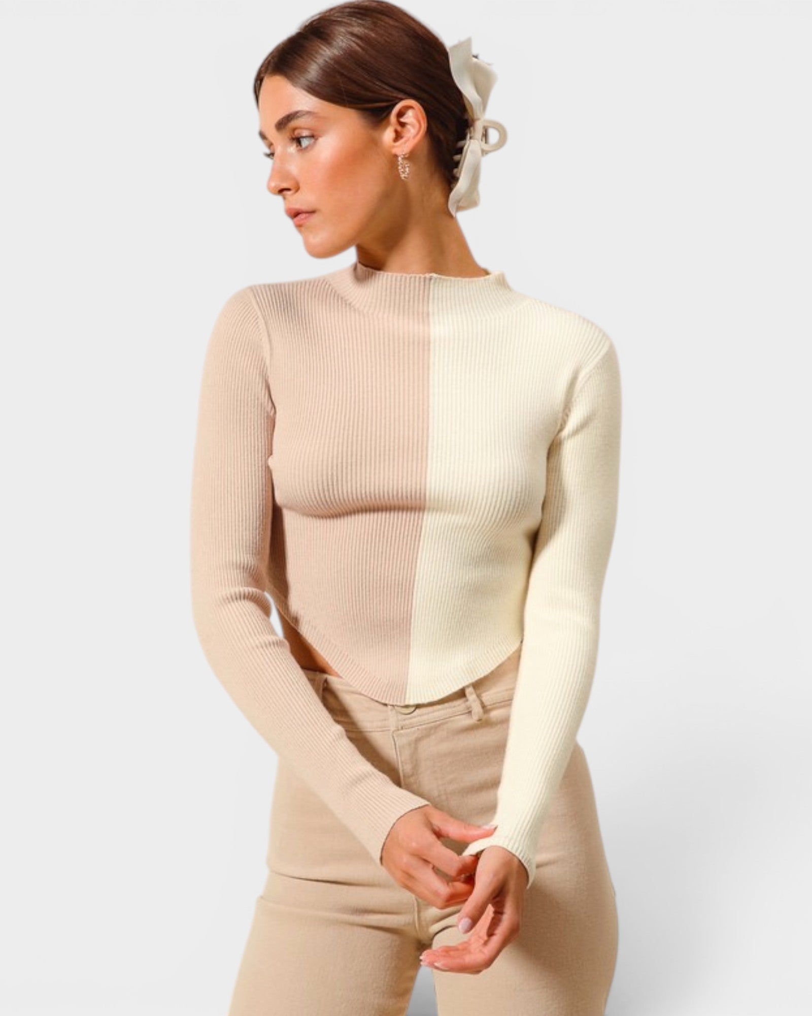 Woman wearing a beige long-sleeve top and pants on a white background