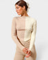 Woman wearing a beige long-sleeve top and pants on a white background