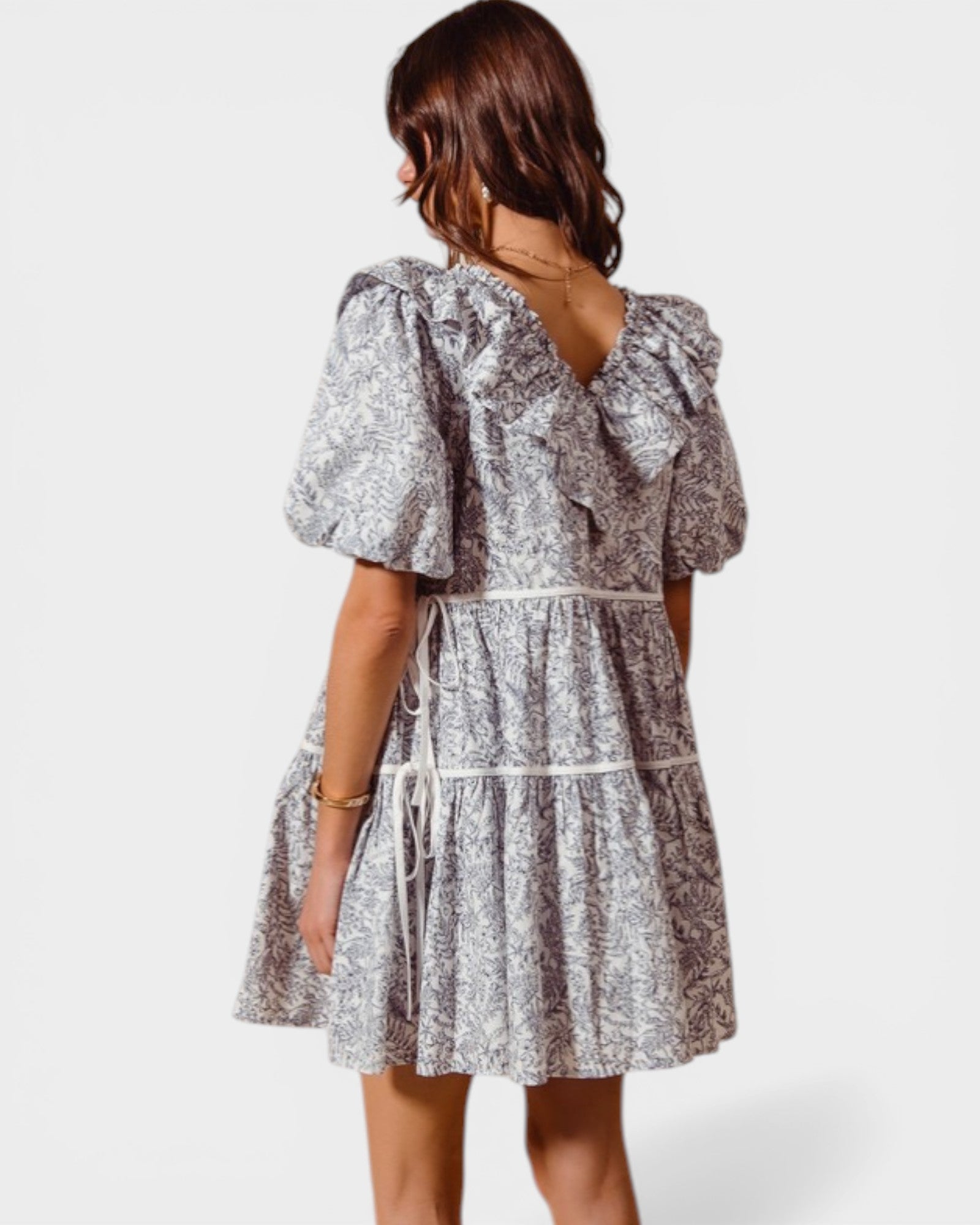 Woman wearing a patterned dress on a white background