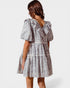 Woman wearing a patterned dress on a white background