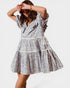 Woman wearing a silver and black patterned dress on a white background