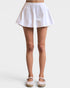 White skirt worn by a person on a plain background