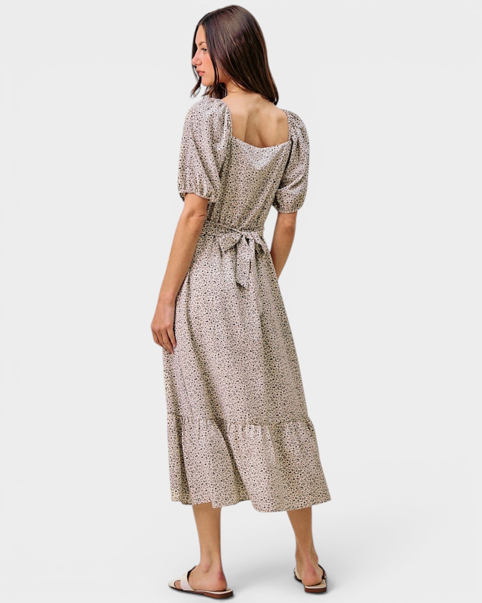 Woman wearing a patterned dress on a white background