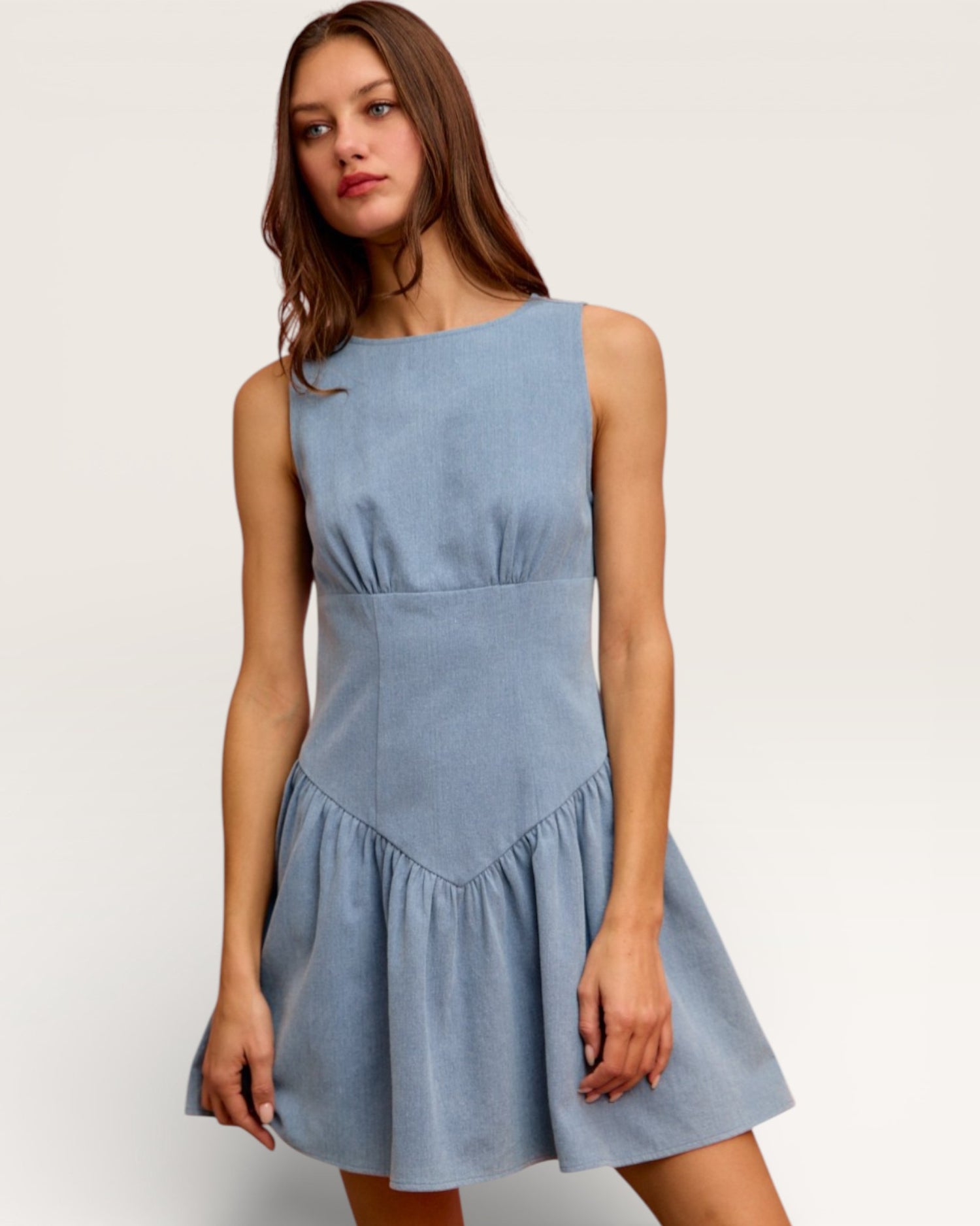 Woman wearing a light blue dress against a plain background