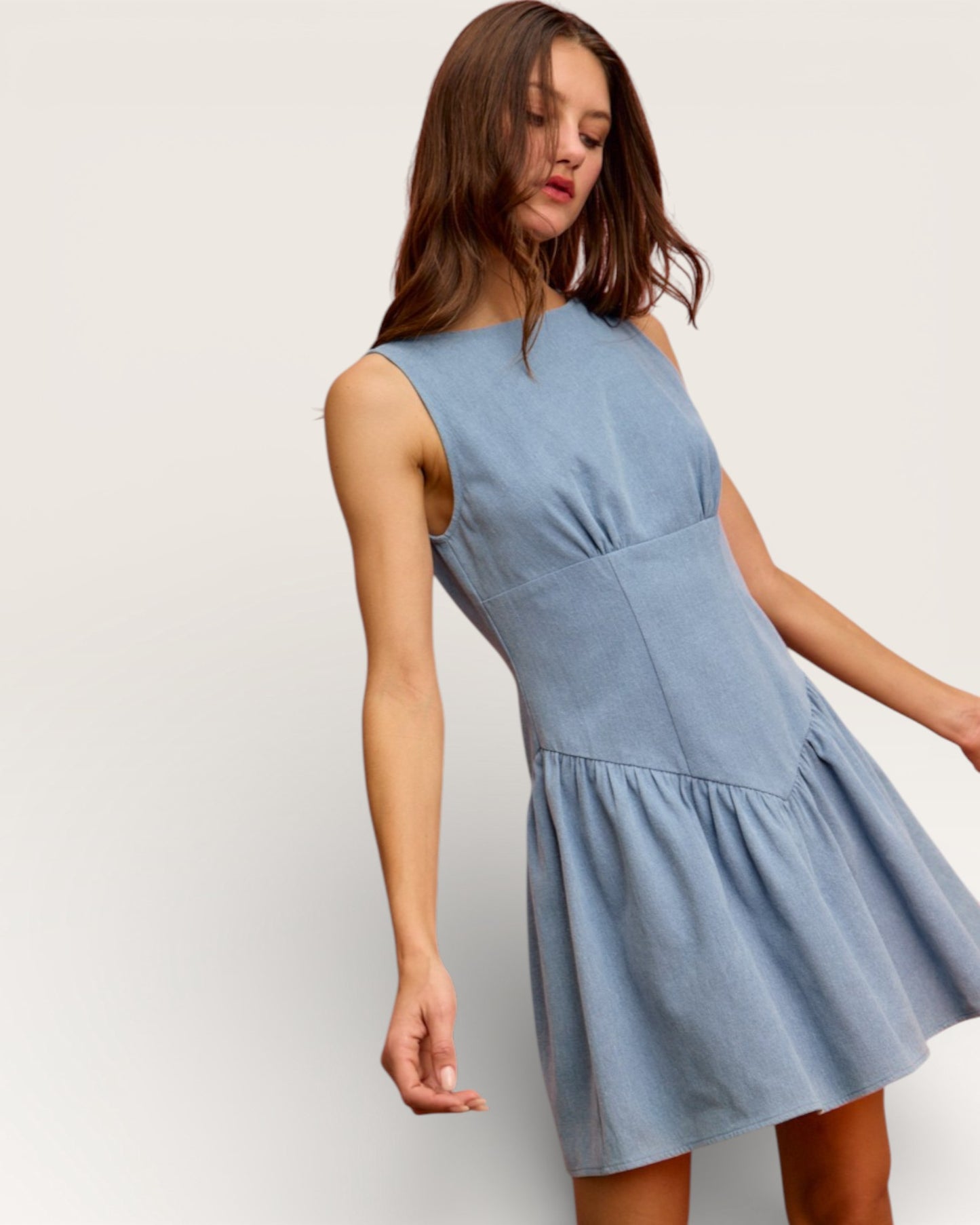 Woman wearing a light blue dress against a plain background