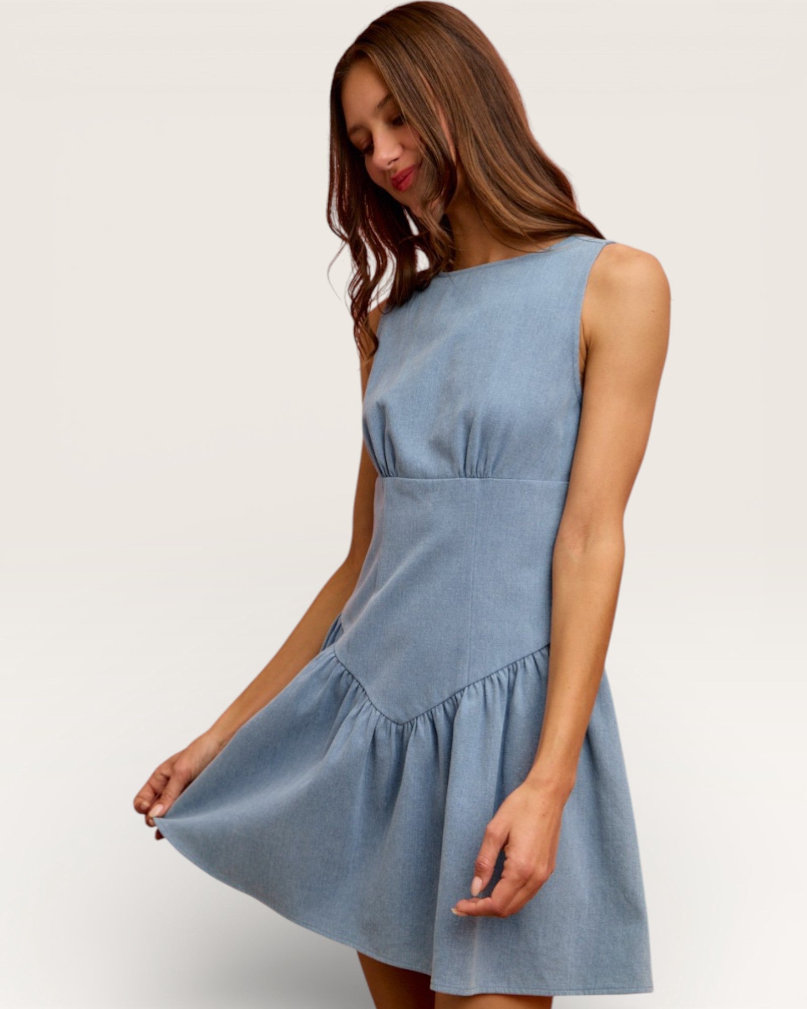 Woman wearing a light blue dress against a white background