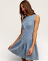 Woman wearing a light blue dress against a white background