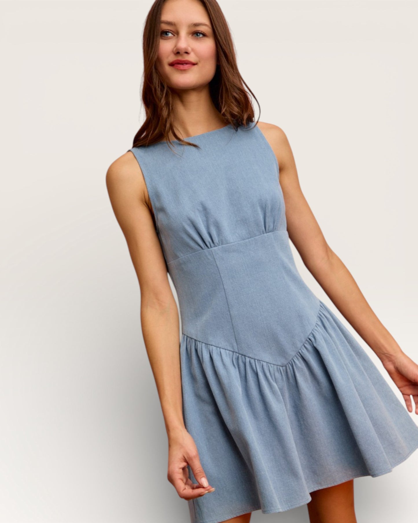 Woman wearing a light blue dress against a white background