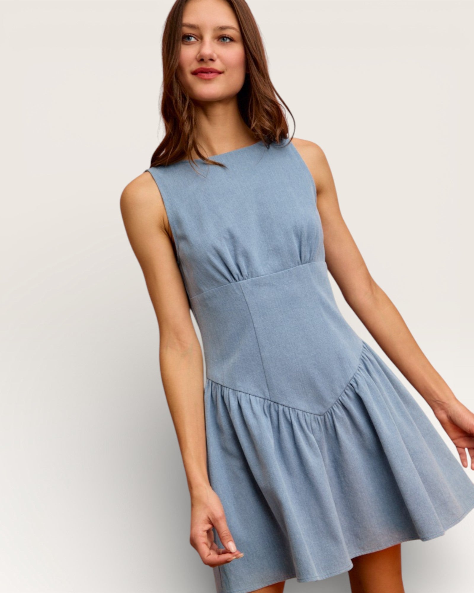 Woman wearing a light blue dress against a white background