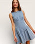 Woman wearing a light blue dress against a white background