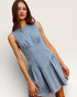 Woman wearing a light blue dress against a plain background