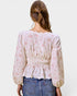 Back view of a person wearing a floral blouse and jeans on a white background