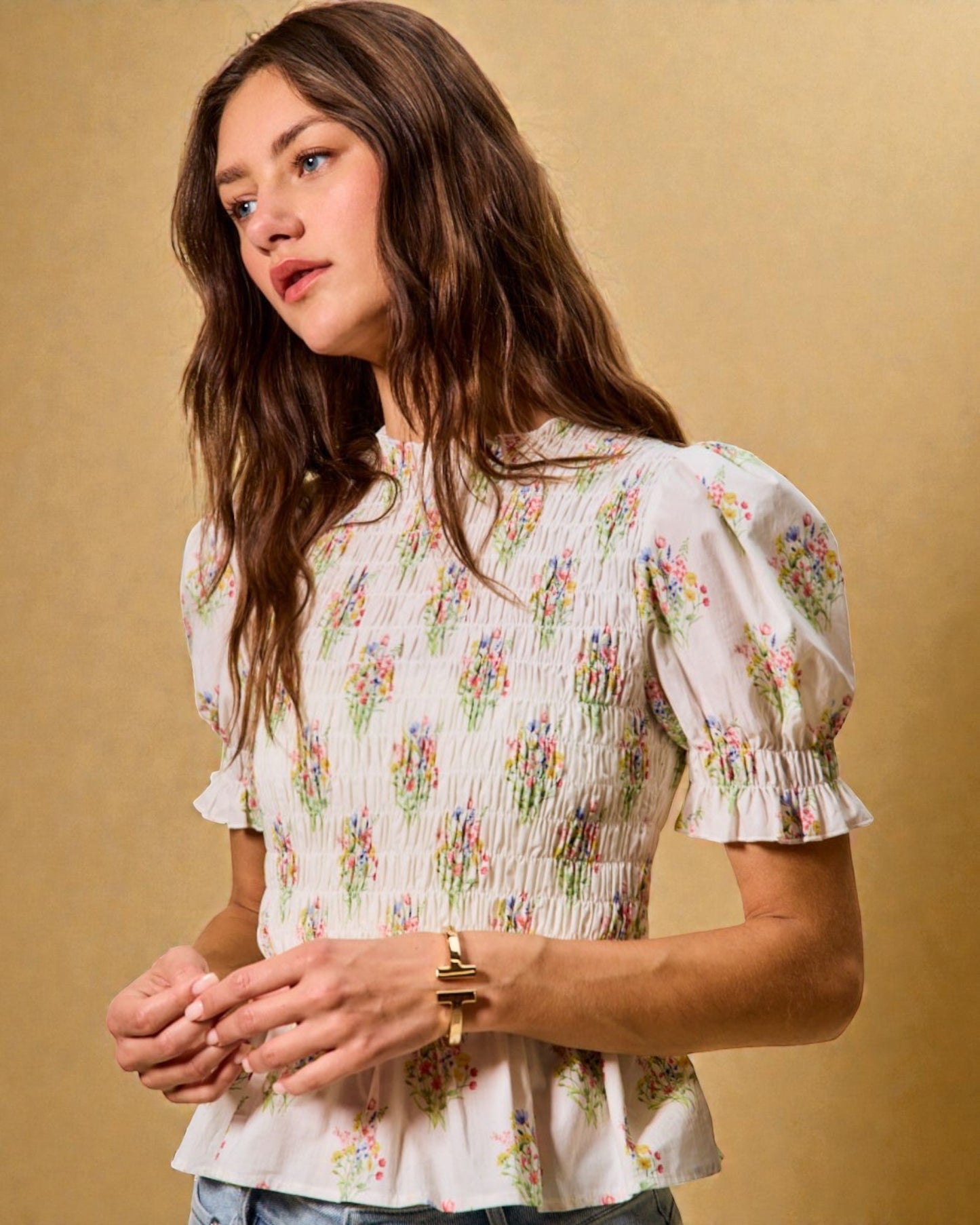 Woman wearing a floral blouse against a beige background