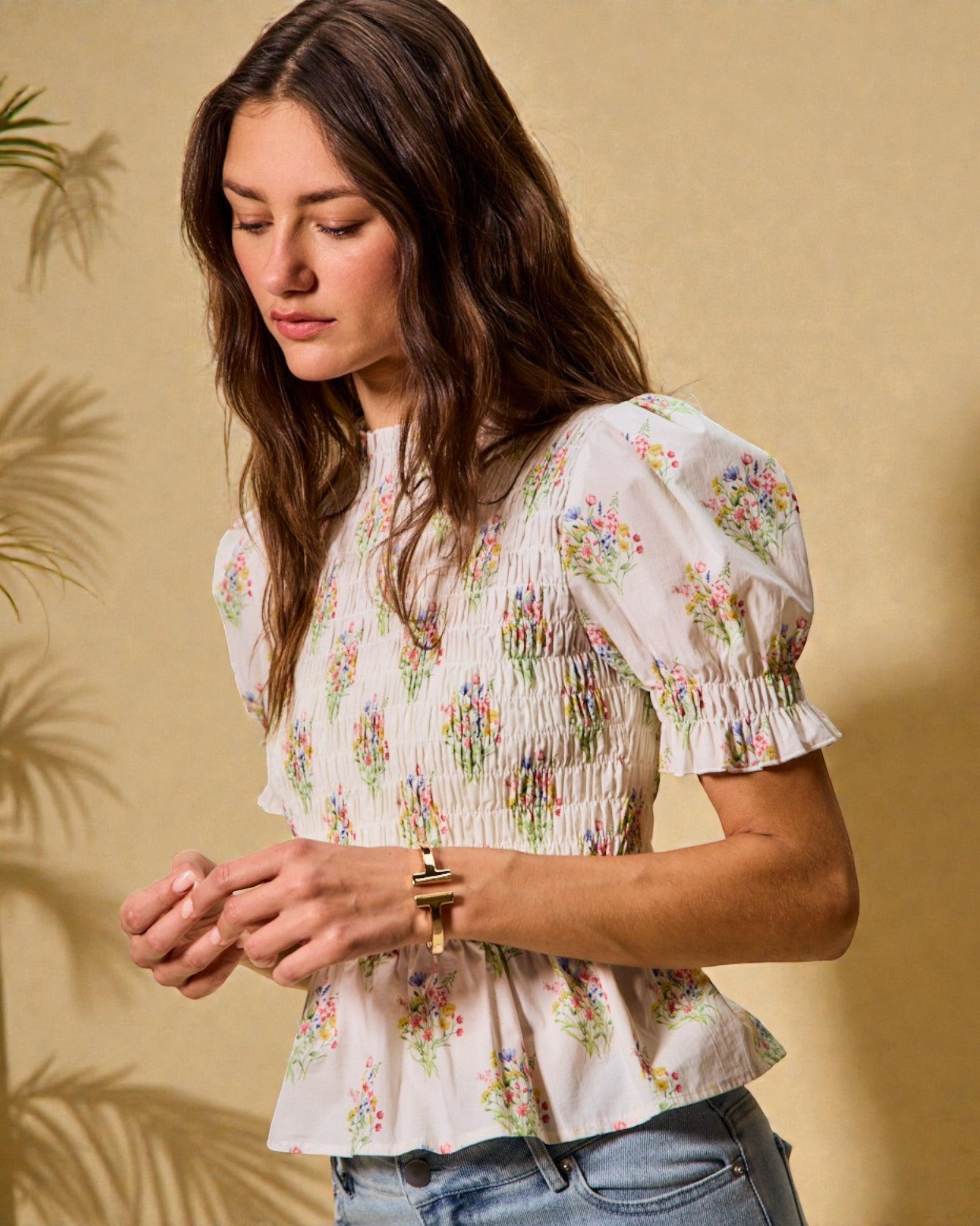 Woman wearing a floral blouse against a beige background