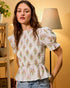 Woman wearing a floral blouse in a home setting