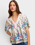 Woman wearing a floral blouse with a plain background