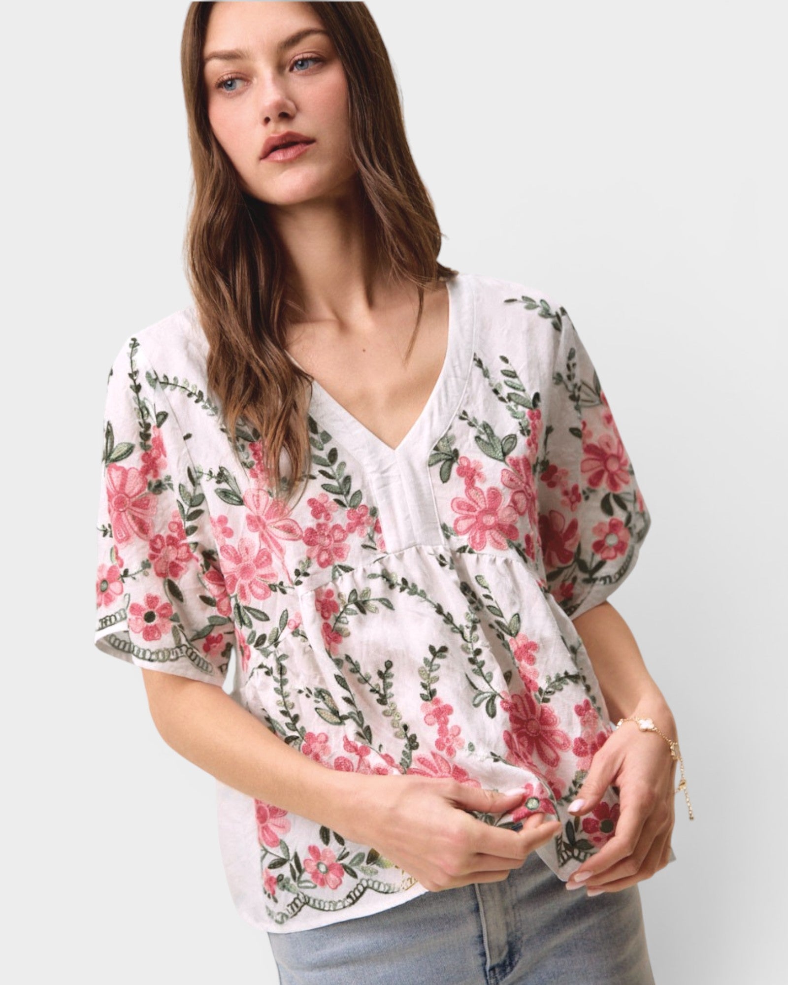 Woman wearing a floral kimono-style top on a plain background