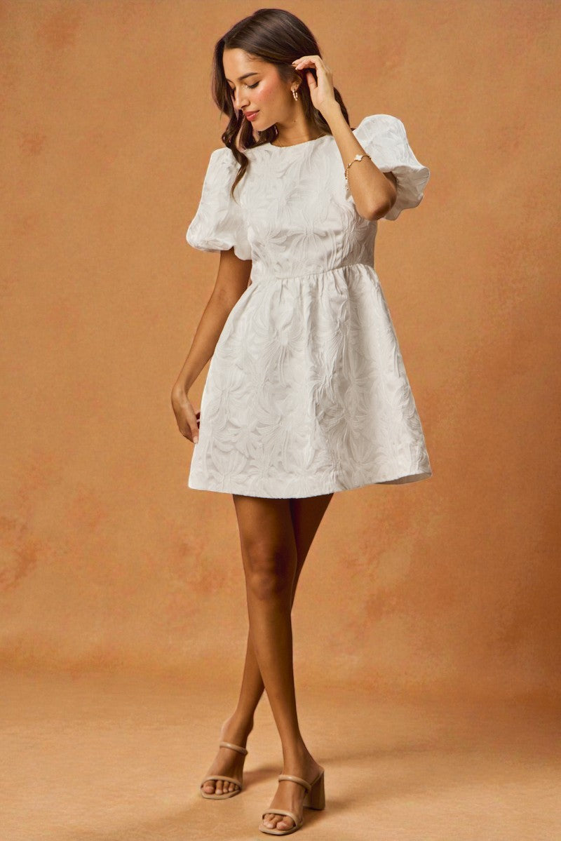 Woman wearing a white dress against a brown background