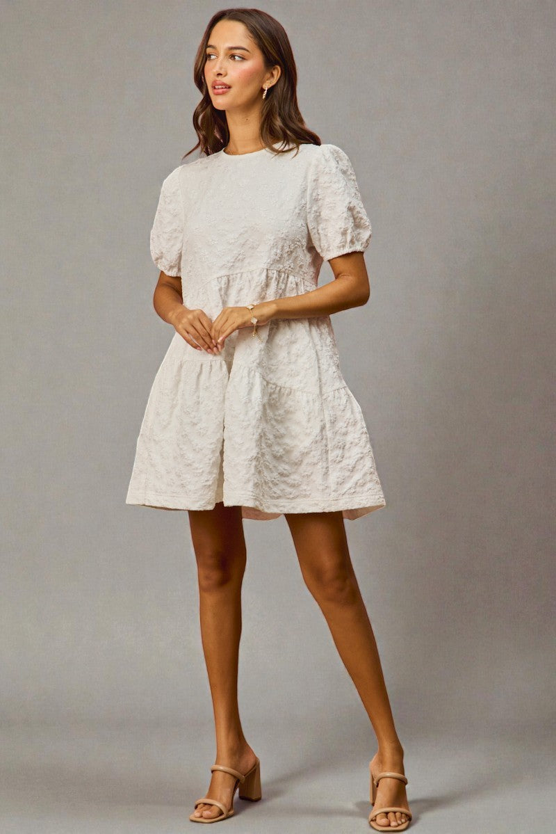 Woman wearing a white dress against a gray background