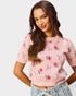 Woman wearing a pink floral sweater against a plain background