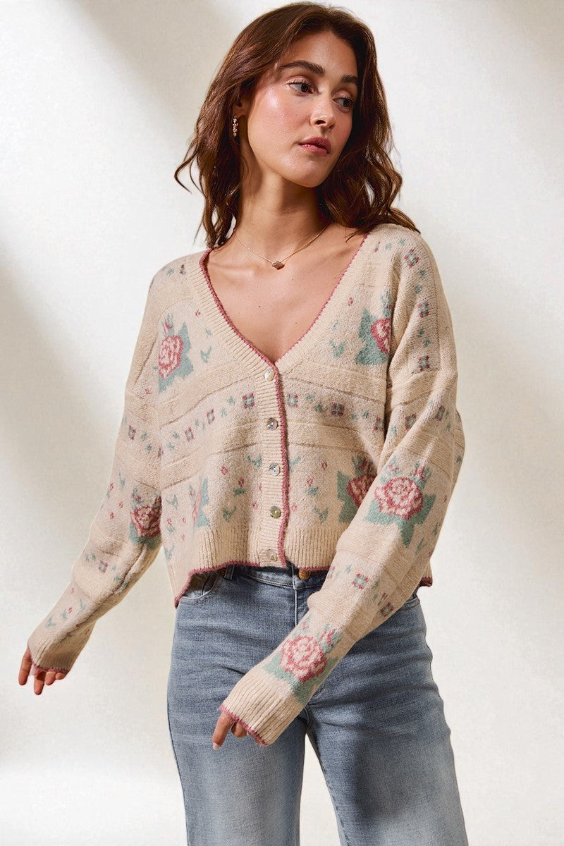 Woman wearing a floral-patterned cardigan against a plain background