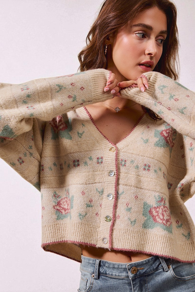 Woman wearing a floral patterned cardigan against a white background