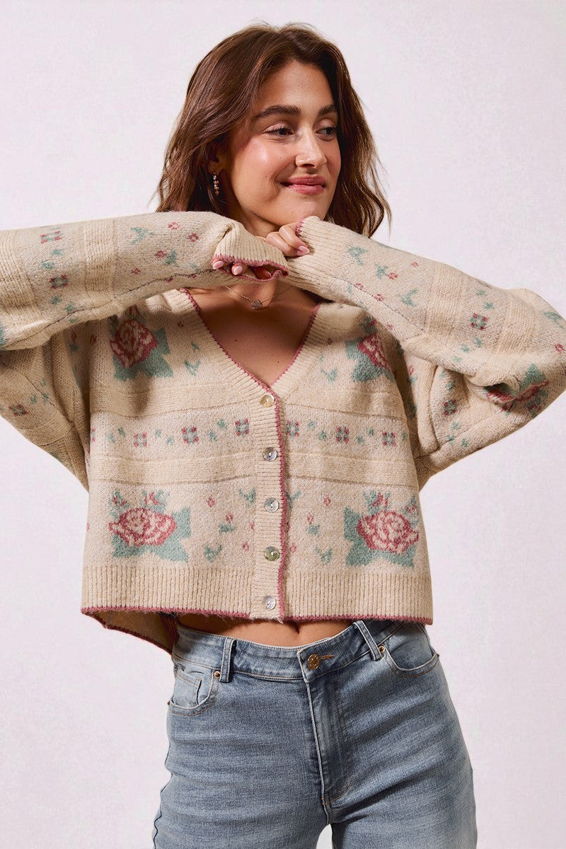 Woman wearing a floral patterned sweater with a plain background