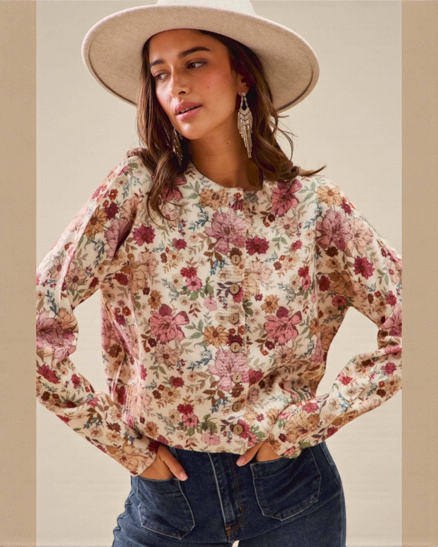 Woman wearing a floral blouse and wide-brimmed hat against a neutral background